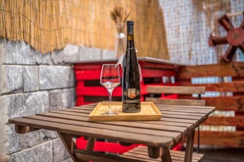 een fles wijn en een glas op een houten tafel bij Modena AL Mulèin - 2 passi dal centro con parcheggio in Modena
