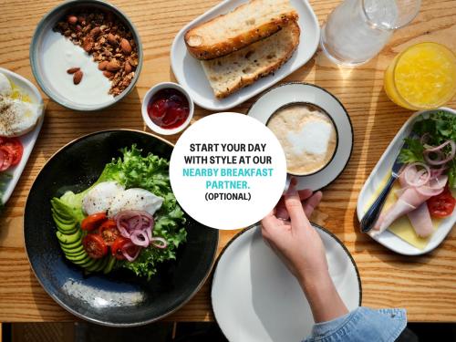 オスロにあるNuma Oslo Hallenの食べ物の皿が置かれたテーブルと「スタート」と書かれた看板を掲げている人