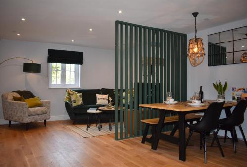 sala de estar con mesa y sofá en Luxury 2-Bed Barn Conversion in Llansteffan, en Carmarthen