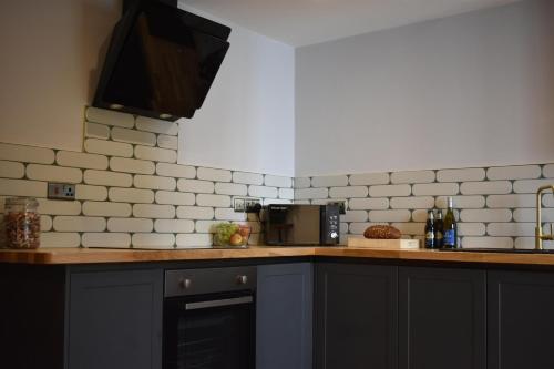 a kitchen with a counter top with a microwave at Yr Hen Beudy Barn Conversion Sleeps 4 Dogs Ok in Carmarthen
