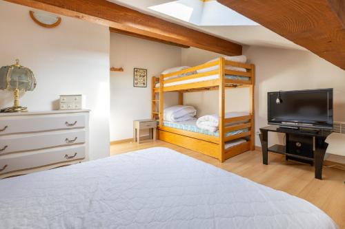 ein Schlafzimmer mit einem Etagenbett und einem TV in der Unterkunft Le Parador - Vue montagne in Les Angles