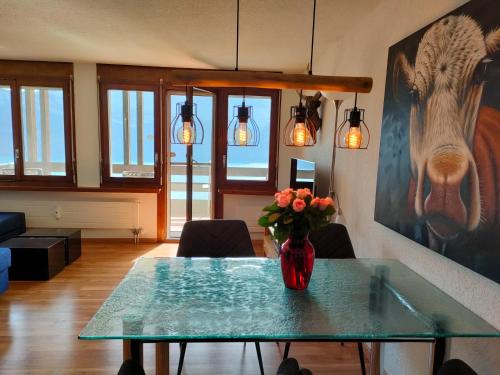 ein Wohnzimmer mit einem Glastisch mit einer Blumenvase in der Unterkunft Camenzind in Gersau