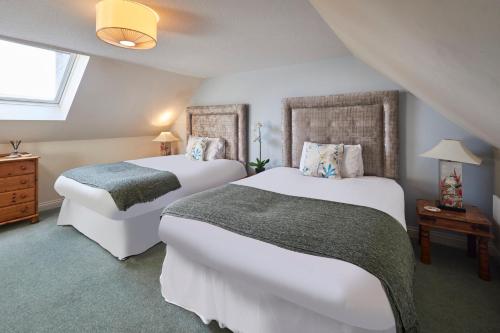 a bedroom with two beds and a table with a lamp at Host & Stay - Grange Cottage in Belford