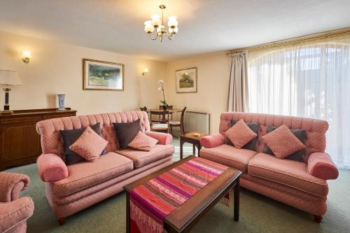 a living room with two couches and a table at Host & Stay - Grange Cottage in Belford