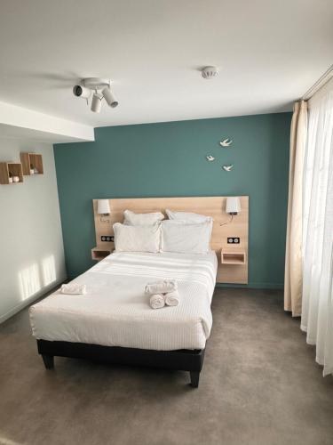 - une chambre avec un grand lit et des serviettes dans l'établissement L'Hirondelle, 