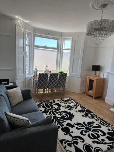 a living room with a blue couch and a black and white rug at The Beach House in Lowestoft