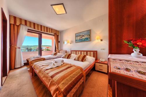 a hotel room with two beds and a window at Hotel Trogirski Dvori in Trogir