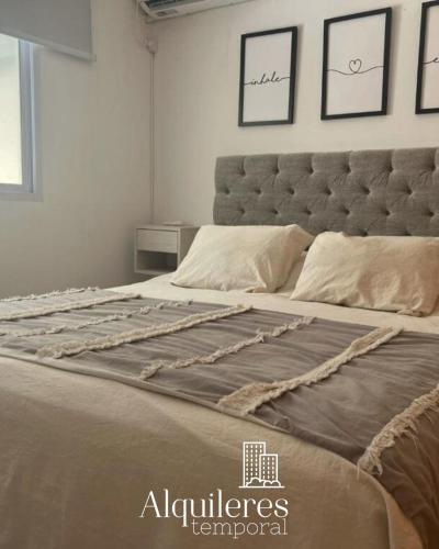 1 cama grande en un dormitorio con cabecero grande en tucuman 2660 en Rosario