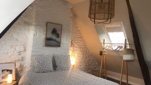 a bedroom with a bed with a stone wall at LA PETITE BRETONNE in Noyal-Muzillac