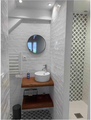 une salle de bain avec un lavabo et un miroir dans l'établissement LA PETITE BRETONNE, à Noyal-Muzillac