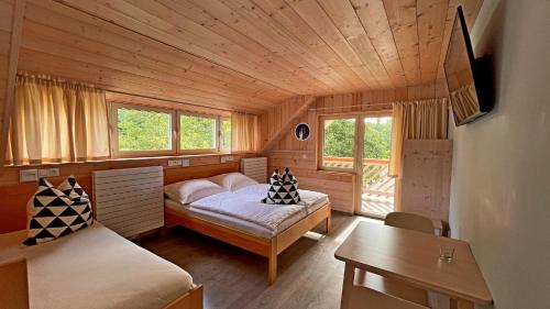 Habitación pequeña con 2 camas y mesa. en penzion a kemp Harasov, en Vysoká