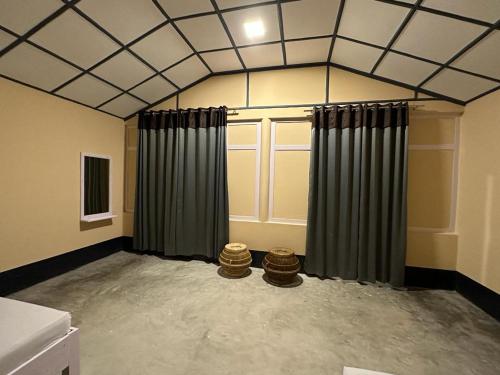 Zimmer mit schrägen Decken und Vorhängen in einem Zimmer in der Unterkunft Camp Buffalo Retreat in Jyoti Gaon