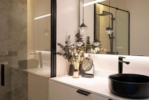 een badkamer met een zwarte wastafel en een spiegel bij Apartamentos Los Maites - 1º Linea de Playa - Vista al mar in Benalmádena