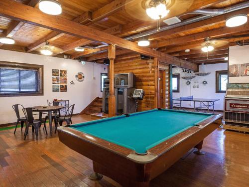 a pool table in a room with wooden ceilings at Kariyushi Condominium Resort Yuudekiya in Onna