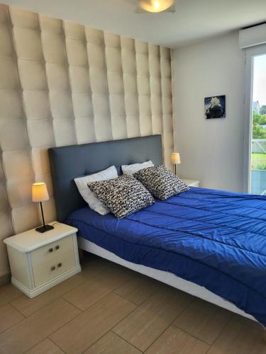 sypialnia z niebieskim łóżkiem i zagłówkiem w obiekcie Grande villa bord de mer w mieście Saint-Germain-sur-Ay