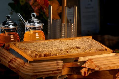 a wooden tray of honey and two bottles of honey at Aktivhotel Alpendorf in Sankt Johann im Pongau