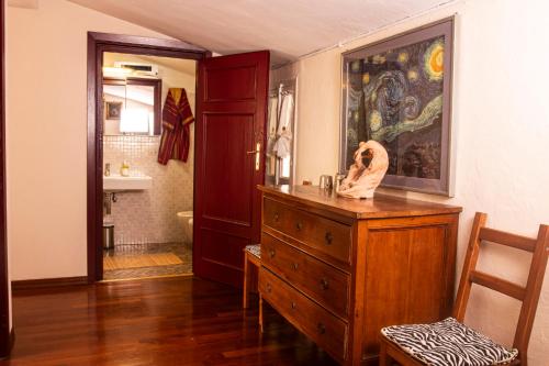 a room with a wooden dresser and a bathroom at Palazzo Micheletti Lucca in Lucca
