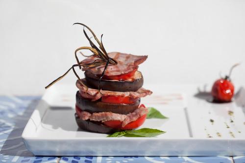 a stack of food on a plate on a table at Quartara Boutique Hotel in Panarea