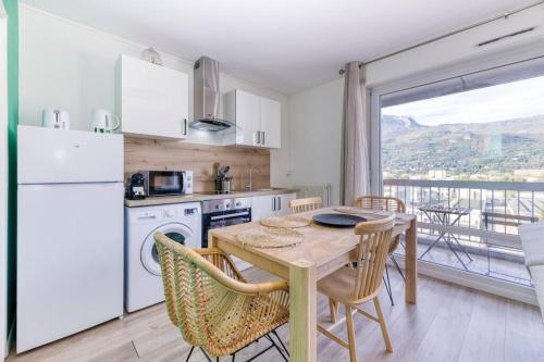 une cuisine avec une table et des chaises et une cuisine avec une fenêtre dans l'établissement Superbe : parking gratuit + fibre wifi + balcon, à Grenoble