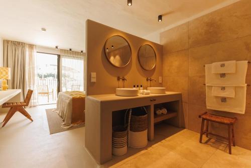 a bathroom with a sink and two mirrors on the wall at Boutique Hotel Los Limoneros in Moraira