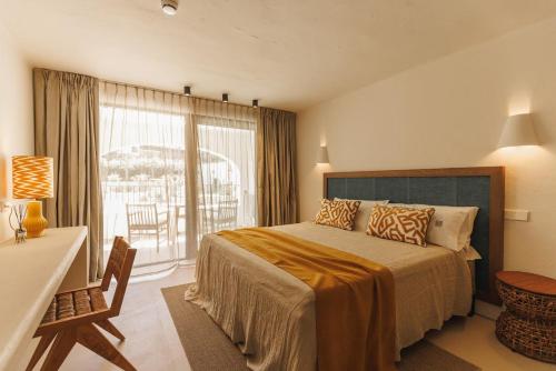 ein Schlafzimmer mit einem Bett und einem großen Fenster in der Unterkunft Boutique Hotel Los Limoneros in Moraira