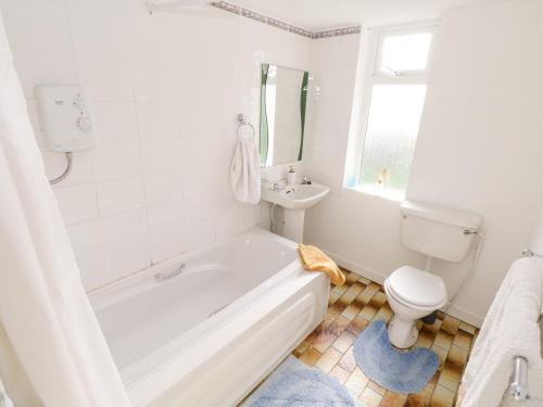 a white bathroom with a tub and a toilet at Lakeside in Ballinrobe
