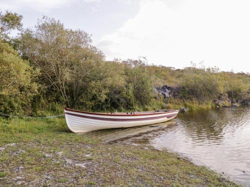 a boat sitting on the shore of a body of water at Lakeside in Ballinrobe