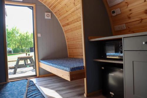 a tiny house with a bed and a window at Wyreside Lakes Glamping Pods in Lancaster