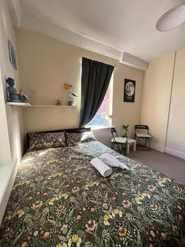 a bedroom with a bed with a floral bedspread at Lovely Flat Like Your Home in Dublin