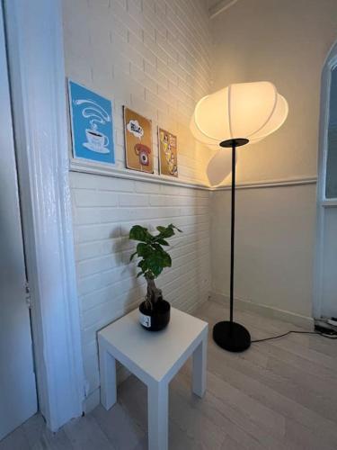 une chambre avec une lampe et une table avec une plante dans l'établissement Lovely Flat Like Your Home, à Dublin