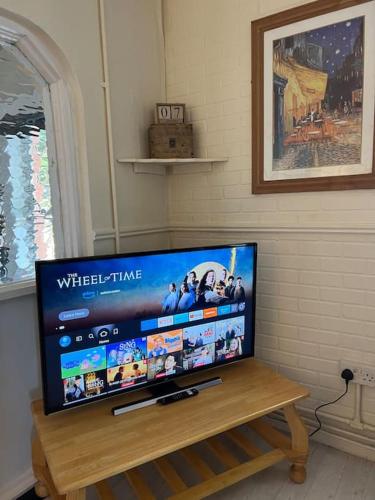 Une télévision à écran plat est installée au-dessus d'une table en bois. dans l'établissement Lovely Flat Like Your Home, à Dublin