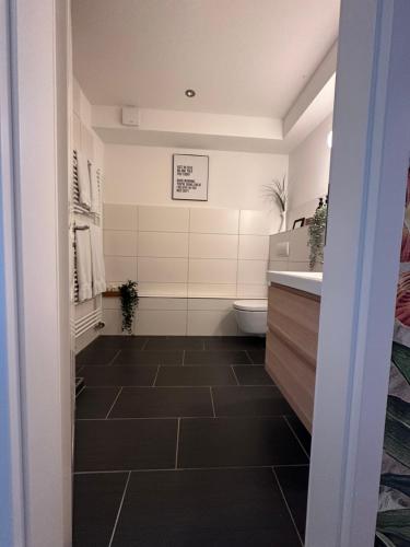 a bathroom with a toilet and a sink at Haus am See B&B in Bornheim