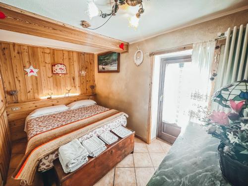 ein Schlafzimmer mit einem Bett in einem Zimmer mit einem Fenster in der Unterkunft Le Grenier de Olga e Mario in Pré-Saint-Didier