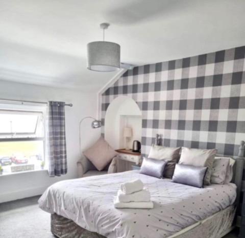 a bedroom with a bed with a checked wall at The Beach House in Lowestoft