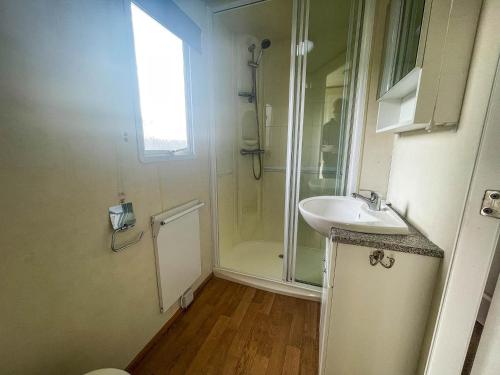 a small bathroom with a sink and a shower at Caravan By The Sea At California Cliffs Holiday Park In Norfolk Ref 50014b in Great Yarmouth