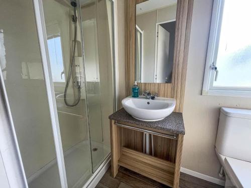 La salle de bains est pourvue d'un lavabo et d'une douche. dans l'établissement Superb 6 Berth, Dog Friendly Caravan For Hire By The Beach In Norfolk Ref 50008m, à Great Yarmouth