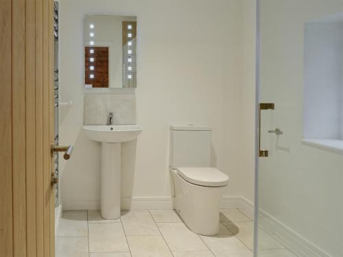 een witte badkamer met een wastafel en een toilet bij Spring Cottage in Kentisbury