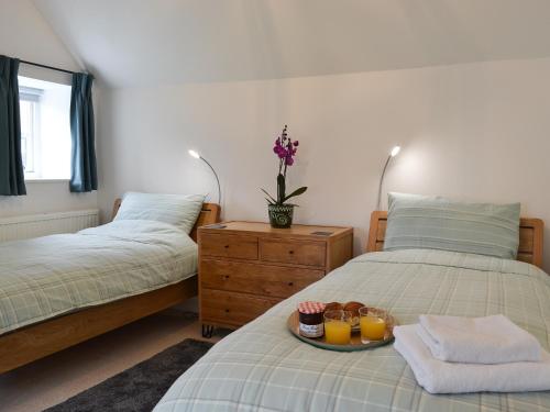 a bedroom with two beds with a tray of food on it at Sunny Cottage in Bulmer