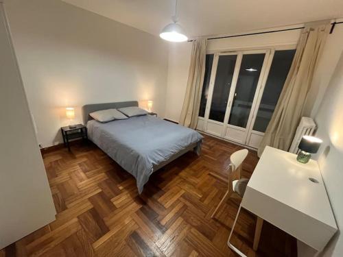 Schlafzimmer mit einem Bett und Holzboden in der Unterkunft 4 personnes - ambiance cosy - proche universités in Grenoble