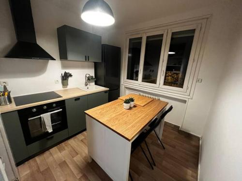 eine Küche mit einem Holztisch und einer Arbeitsplatte in der Unterkunft 4 personnes - ambiance cosy - proche universités in Grenoble