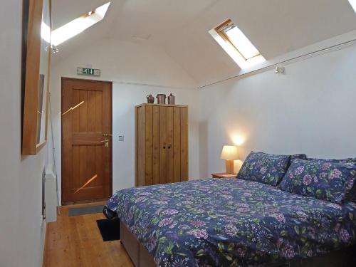 um quarto com uma cama e uma porta de madeira em The Studio em Hoe