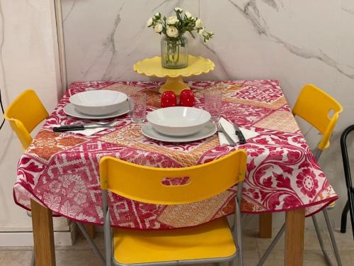 a dining room table with a red and yellow table cloth at Tourist House Bologna - Self check-in in Bologna