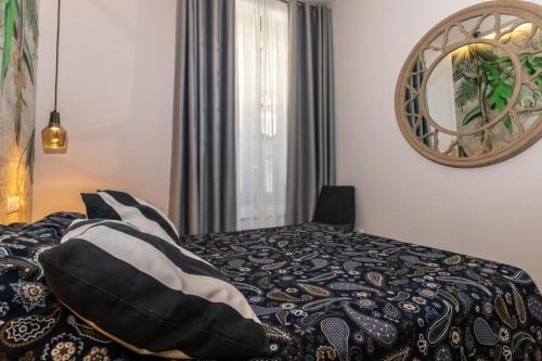1 dormitorio con 1 cama con espejo en la pared en TRIANA INES, en Sevilla