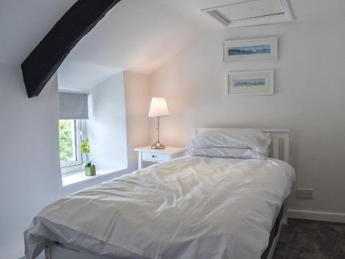 sypialnia z białym łóżkiem i oknem w obiekcie Pollards Cottage w mieście Forrabury