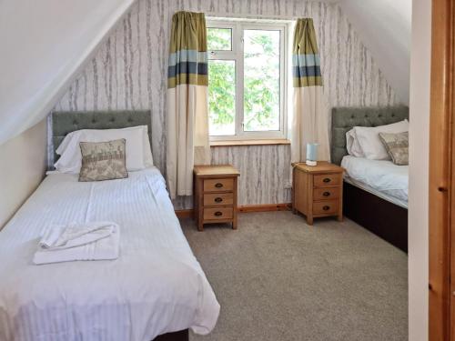 1 dormitorio con 2 camas y ventana en Dartmoor 3, en Gunnislake