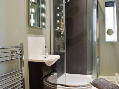 a bathroom with a glass shower and a sink at Sycamore Cottage in Consett
