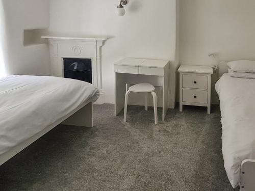 a bedroom with a bed and a desk and a bed sidx sidx sidx at Haycraft Cottage in Langton Matravers