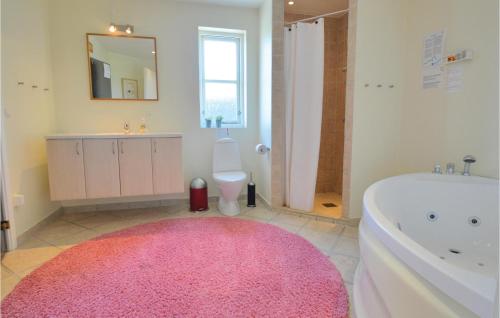 een badkamer met een roze tapijt, een bad en een toilet bij Lovely Home In Hemmet With Wifi in Falen