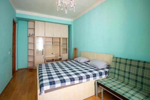 um quarto com uma cama e um sofá em Funicular Apartments em Tbilisi