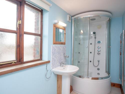 a bathroom with a shower and a sink at The Old Mill House in Welcombe